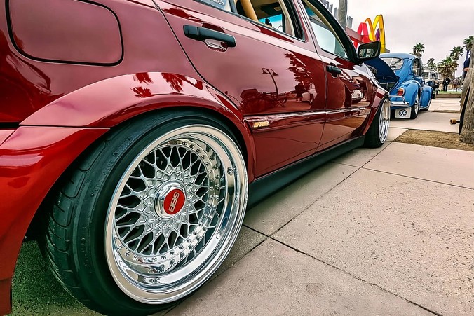Burgundy Volkswagen MK3 Golf with OptikWerks widebody fender flares and deep dish wheels