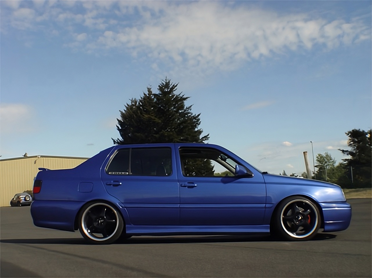 Blue Volkswagen MK3 Jetta side profile with OptikWerks smoothed ABT style side skirts