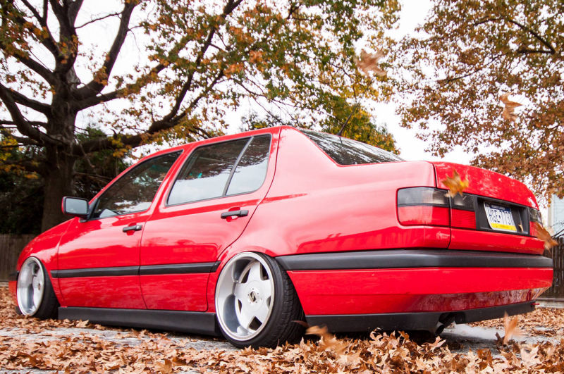 Red Volkswagen MK3 Jetta rear view with textured side skirts