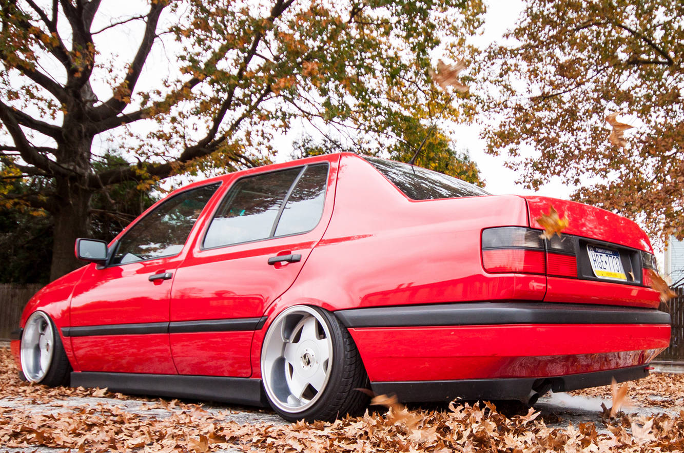 Red Volkswagen MK3 Jetta rear view with textured side skirts