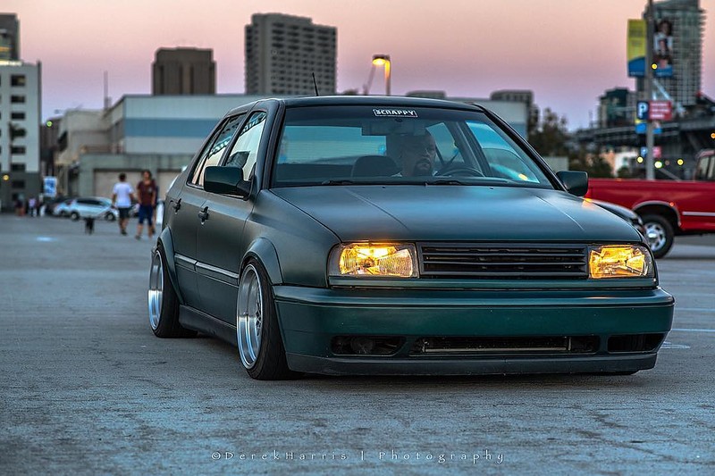 Green Volkswagen MK3 Jetta with widened Euro flares, front view at dusk
