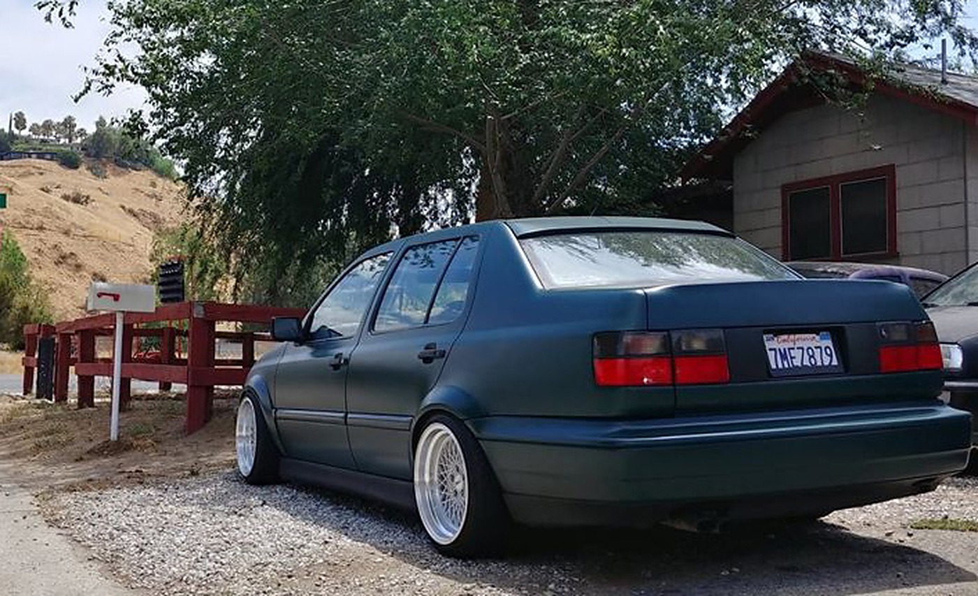 Green Volkswagen MK3 Jetta rear three-quarter view fitted with OptikWerks widened Euro fender flares