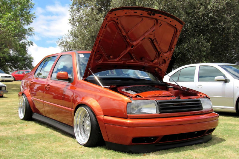 Front quarter view of Volkswagen Jetta MK3 Vento with Optikwerks wide body kit, fender flares, lowered stance and polished deep dish wheels