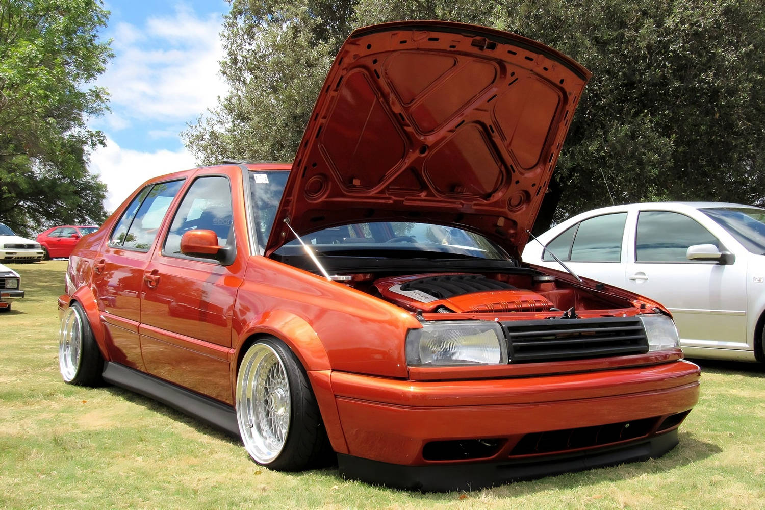 Front quarter view of Volkswagen Jetta MK3 Vento with Optikwerks wide body kit, fender flares, lowered stance and polished deep dish wheels