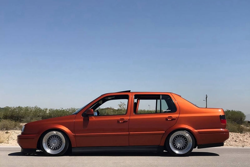 Side profile of Volkswagen Jetta MK3 Vento with wide body kit, fender flares, lowered stance and polished wheels by Optikwerks
